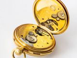 a close up of a pocket watch on a white surface