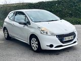 a white car parked in a parking lot next to a hedge
