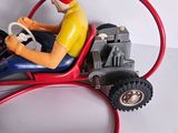 a figurine of a man driving a toy car