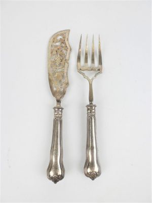 deux fourchettes et un couteau sur une surface blanche