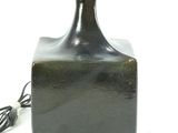 a small black bottle with a light on top of it
