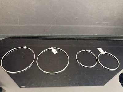trois bracelets en argent posés sur une boîte noire