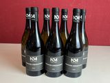 quatre bouteilles de vin sont alignées sur une table