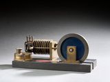 une petite maquette de machine à vapeur posée sur un socle