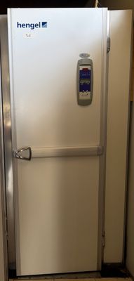 un réfrigérateur blanc dans un coin d'une pièce dont la porte est ouverte