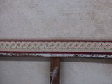 a white wall with a red border and a clock on it