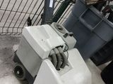 une machine posée par terre à côté d'une poubelle