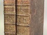 deux vieux livres posés l'un sur l'autre sur une surface blanche
