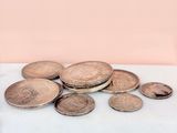 several coins are sitting on a table next to a glass of water