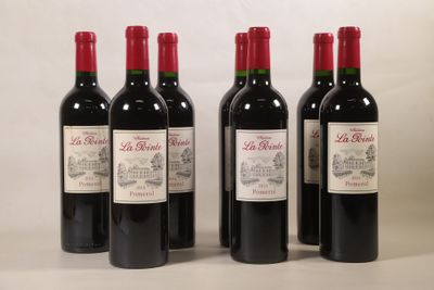 quatre bouteilles de vin rouge sont alignées sur une table