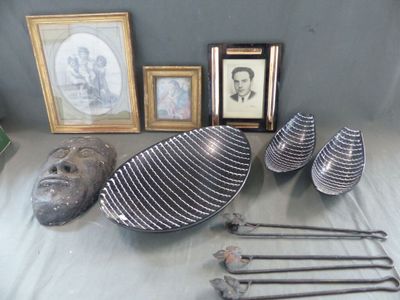 Plusieurs œuvres d'art sont exposées sur une table, à côté d'une photo encadrée.