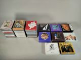 de nombreux CD posés sur une table, sur fond blanc