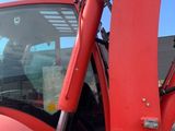 a red tractor that is parked in the parking lot