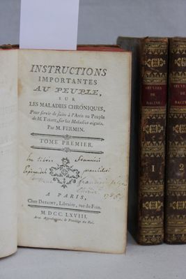 plusieurs vieux livres sont alignés sur une étagère, les uns à côté des autres