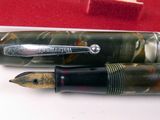 two fountain pens sitting next to each other on a table