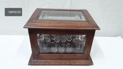 a glass case with wine glasses in it on a table