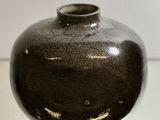 un vase noir posé sur une table en verre