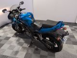 a blue motorcycle that is parked on a checkered floor