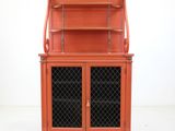 an orange cabinet with a glass door and a shelf on top of it