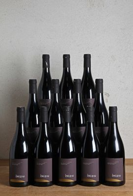 bottles of wine sit on a wooden table in front of a wall