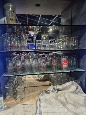de nombreux verres vides sur les étagères de la pièce
