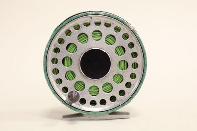 a close up of a fly reel on a white surface