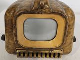 antique brass plated tv with glass screen on stand on a white surface