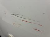 a white car with red paint on the side of it