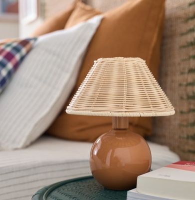 une petite table sur laquelle est posée une lampe, à côté d'un lit