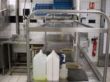 a metal cart with bottles and containers on it in a kitchen