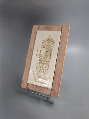 une photo d'une plaque en bois sur laquelle figure le portrait d'un homme