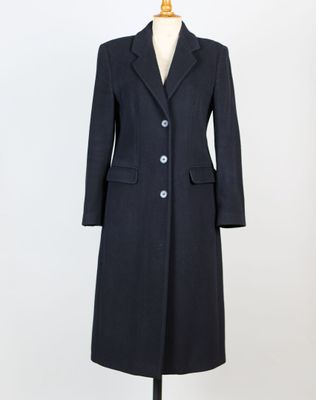Ce manteau est en laine et comporte des boutons sur le revers.