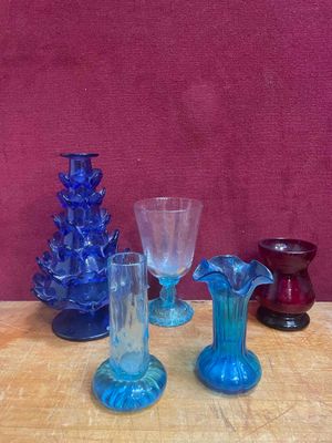 de nombreux vases en verre de différentes couleurs sur la table