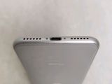 the back of a silver cell phone sitting on top of a table
