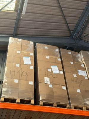 Les cartons sont empilés sur une palette dans un entrepôt doté d'une verrière.