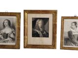 Trois portraits encadrés représentant des femmes et un chat sont accrochés au mur.