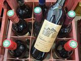 plusieurs bouteilles de vin posées dans une caisse rouge