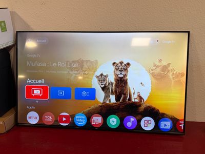 the flat screen tv is sitting on a red table in front of a wall