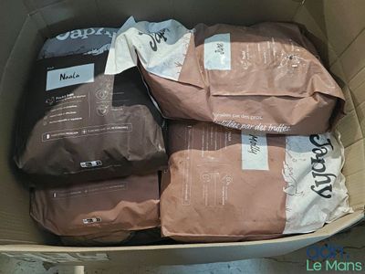 plusieurs paquets de café dans une boîte posée par terre