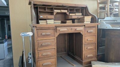 un bureau en bois muni de tiroirs et surmonté d'une bibliothèque