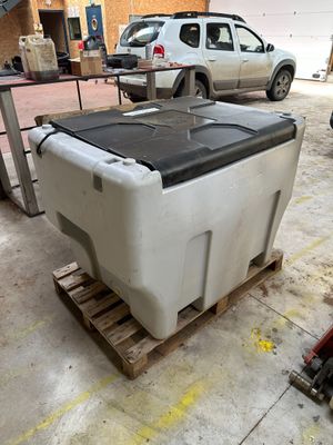 une grande glacière posée sur une palette dans un garage
