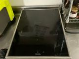 a black stove top sitting on a counter in a kitchen