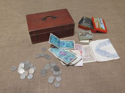 a wooden box filled with money and coins on a table