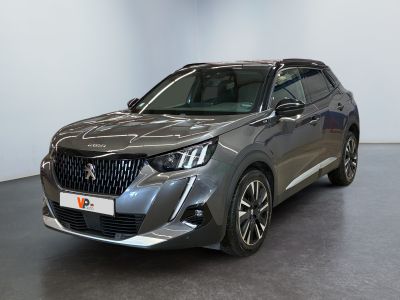 un SUV gris garé dans une pièce aux murs blancs