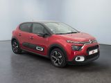 a red citrole is parked in front of a white wall