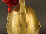 an old helmet with a red feather on top of it