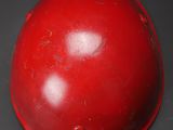 a red baseball helmet on a black surface