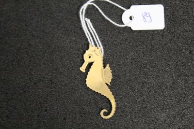 a gold seahorse that is hanging from a string