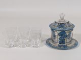 a blue and white jar and glasses on a white table