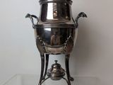 a silver plate with a lid on a glass table